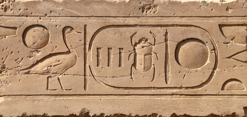 Ancient Egyptian hieroglyphs on stone wall, Karnak Temple Complex, Luxor, Egypt, Africa. Stone...