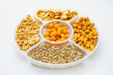 Salt food snacks collection assorted of nuts, seeds and corn on the plate isolated on white background.
