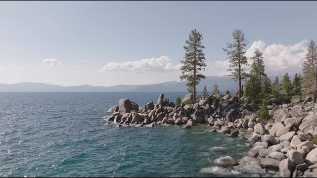 Aerial shot of Lake Tahoe, overlooking part of the lake and rocky cliffs.
