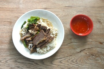 braised  slice cow leg stew black Chinese herb soup eat couple boiled Chinese kale on plain rice in plate dipping spicy sour chili sauce