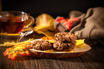 Autumn Still Life with Oatmeal Cookies, Hot Tea, Pumpkins, Candles, and Yellow Leaves
