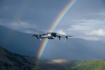 Drone taking photo of rainbow with a drone on high altitude grassland mountain top