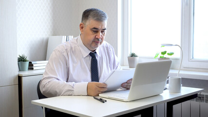 Fototapeta premium Man Working with Documents at Office Desk