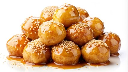 Golden brown loukoumades drizzled with honey and sprinkled with sesame seeds, isolated on white background