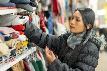 A young woman chooses winter clothes in a store