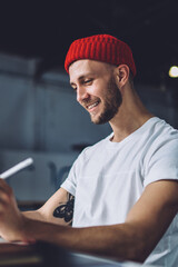 Positive Caucasian male artist using stylus for drawing electronic sketches during time for...