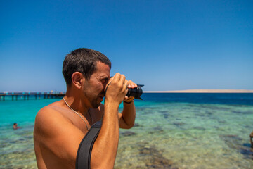 Male photographer on the seashore. Selective focus.