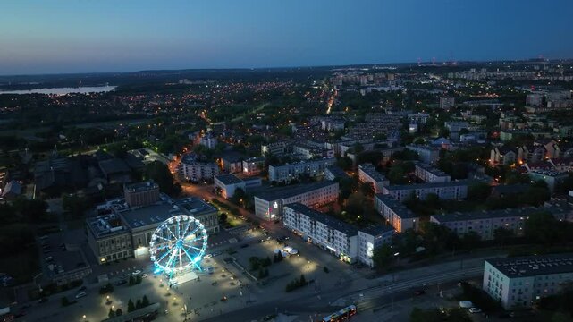 Large colorful Ferris wheel in city center. Aerial drone view on Colorful Ferris wheel spinning in the city center Dabrowa Gornicza Poland. Colorful Ferris wheel From a bird's eye view drone at night.
