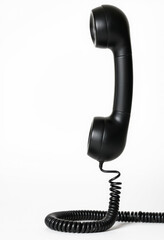 Black telephone handset with cord suspended