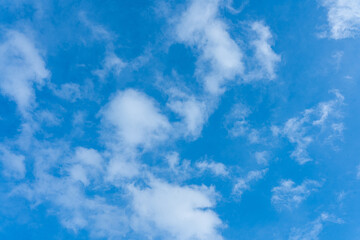 Beautiful fluffy white clouds drift across a clear blue sky, creating a breathtaking natural masterpiece