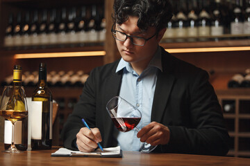 Man Writing Notes in Tasting Card at Wine Bar