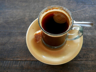 A cup of coffee with brown sugar separately on a table