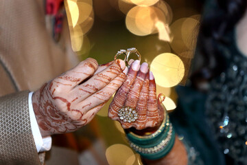 A moment of togetherness, marked by intricate henna designs and gentle hands, symbolizing love and commitment.