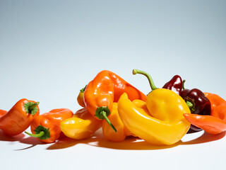 Pile of long sweet peppers over light blue background