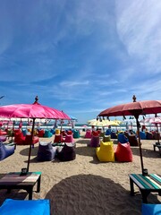 beach paradise with colorful umbrellas and bean bags under a clear blue sky
