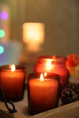 Burning candles and cone on tray indoors, closeup. Autumn atmosphere