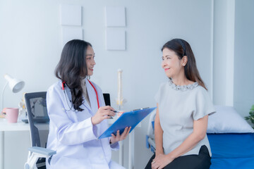 Fototapeta premium A doctor is giving advice to a patient who is coming for treatment about she's illness.