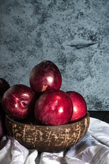 Juicy Summer Plums: Fresh Red and Black Plums on a Rustic Wooden Background