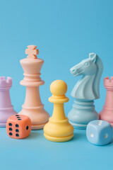 A playful arrangement of pastel-colored chess pieces and dice on a bright blue background. The vibrant pastel tones and minimalist style create a fun, modern twist on a classic game.