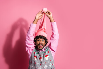 Photo of cheerful positive guy dressed ornament vest santa headwear enjoying x-mas eve emtpy space isolated color background