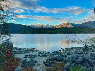 Eibsee lake near Zugspitze, framed by the stunning Alps mountain range in the background. The crystal-clear waters and majestic peaks create a breathtaking alpine landscape.