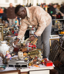 Man looks at second-hand items at a flea market