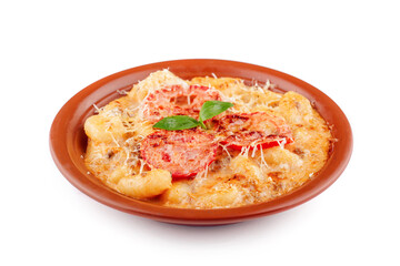 Gnocchi with melted cheese, tomato and basil is served on a plate