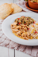 Chicken with rice, eggplant salad and bread on white rustic table setting