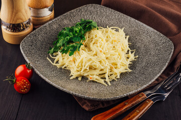 Plate of spaghetti with cheese sauce and parsley on rustic wooden table