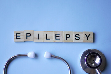 EPILEPSY, wooden blocks with letters and stethoscope with light blue background. medicine concept