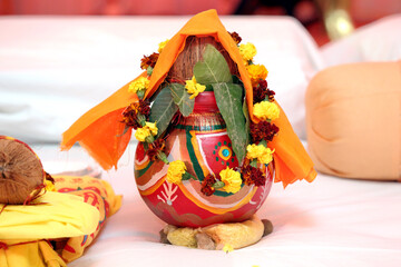 A beautifully decorated Kalash, adorned with vibrant flowers and leaves, symbolizing purity and...