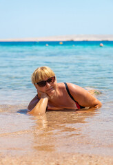 Woman relaxing on the beach in the sea. Selective focus.