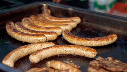 Grilled sausages in frying pan, outdoor cooked meats, delicious barbecue concept