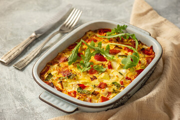 Casserole with zucchini, cheese, eggs, tomatoes, green onions and salmon pieces. Keto.