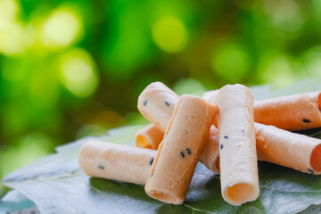 khanom thong muan, Thai cookies on a green leave table with green bokeh nature background