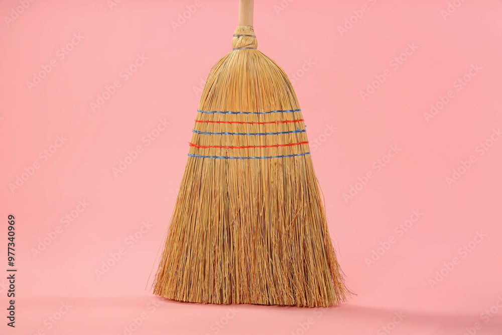 Wall mural One corn straw broom on pink background