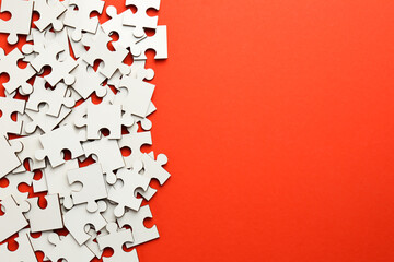White puzzle pieces on red background, top view. Space for text