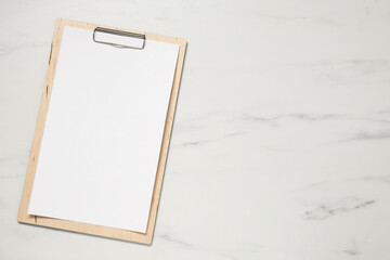 Clipboard with empty paper on white marble table, top view. Mockup for design