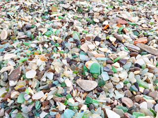 Close-up of the colorful pebbles and glass fragments that make up the beach at Glass Bay in Vladivostok. background, texture, pattern, frame, place for text, copy space