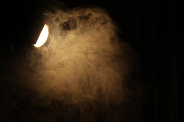 Obraz premium Professional spotlight and smoke in darkness. Space for text