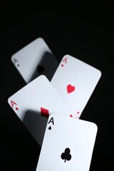 Poker game. Playing cards on black background, closeup