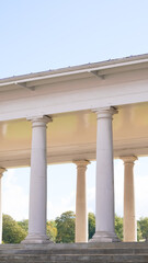 Fototapeta premium :Majestic antique English white columns from a historic building exterior.