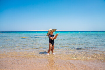 Children on the beach in a hat. Selective focus.