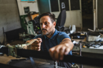 Focused adult man work with tools in a cluttered workshop setting