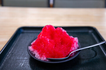 小皿に盛られた苺シロップのかき氷