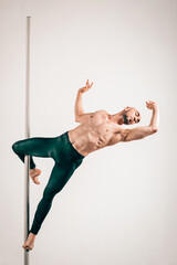 Young strong pole dancer in cupid pose