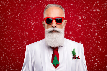 Photo of serious old bearded groomed cool man wear sunglass christmas white suit isolated on red color background