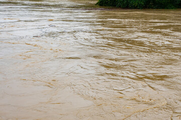 The streams of a stormy river during flooding after heavy rains.