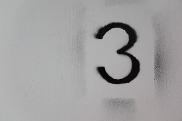 close up of black number three (3) painted on the white floor that is old and torn out with copy space