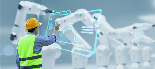 Engineer monitoring robotic AI arms in manufacturing factory plant, manager managing controlling using computer holographic ui display analysis innovation technology, male engineer, banner background.